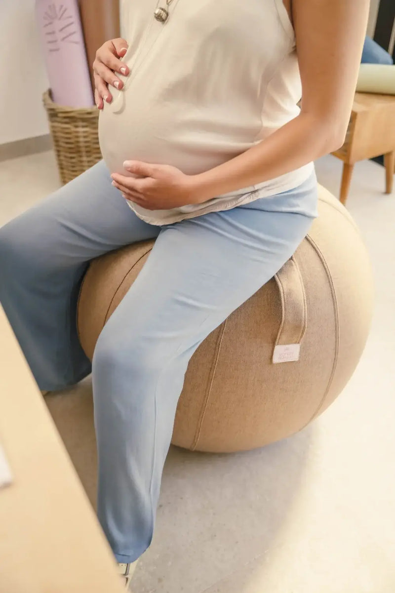 mujer haciendo ejercicios de pilates con pelota fitball en casa
