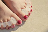 separadores de silicona colocados entre los dedos del pie, con esmalte rojo